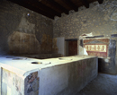 Pompei, Termopolio di L. Vetutius Placidus. Il larario e parte del bancone con i contenitori per cibi e bevande: in uno di essi si rinvenne un gruzzolo di monete. SSBANP/AF, Dia 35742